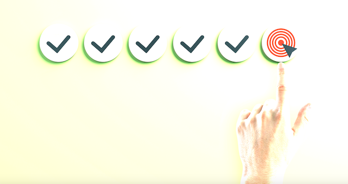 five ticks in circles and a finger pointing to a target.