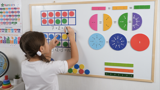 Young student at white board in maths lesson